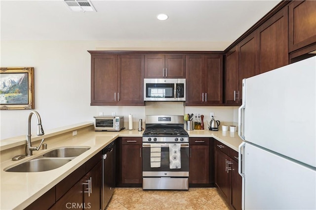 kitchen featuring stainless steel appliances, light tile patterned flooring, sink, and dark brown cabinetry