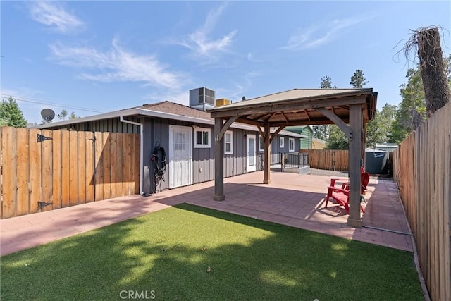 back of property with a gazebo, cooling unit, a patio area, and a lawn