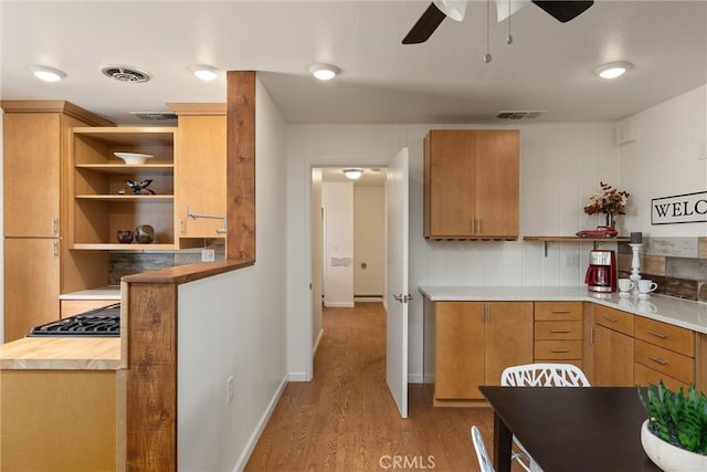 kitchen with ceiling fan, light wood-type flooring, and baseboard heating