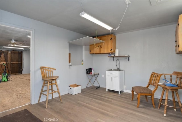 sitting room featuring ceiling fan, light wood-type flooring, and sink