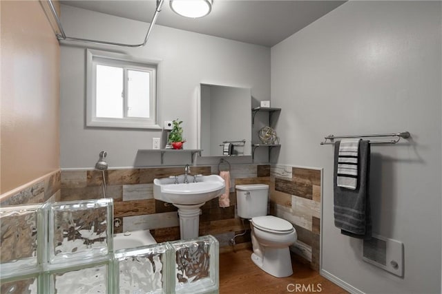 bathroom with a bathing tub, sink, wood-type flooring, and toilet