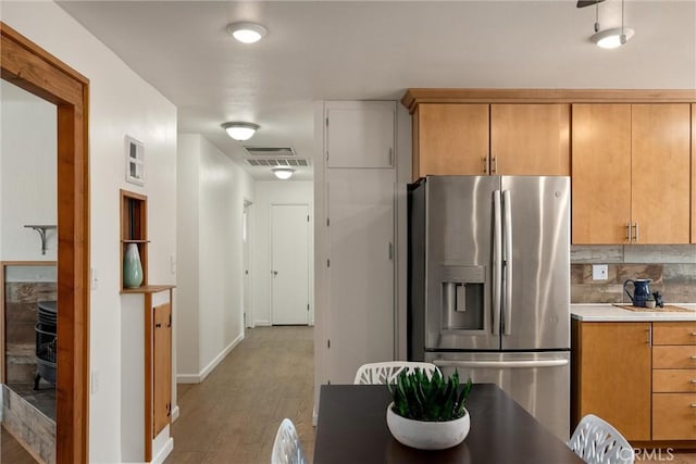 kitchen featuring backsplash, stainless steel fridge with ice dispenser, and hardwood / wood-style floors