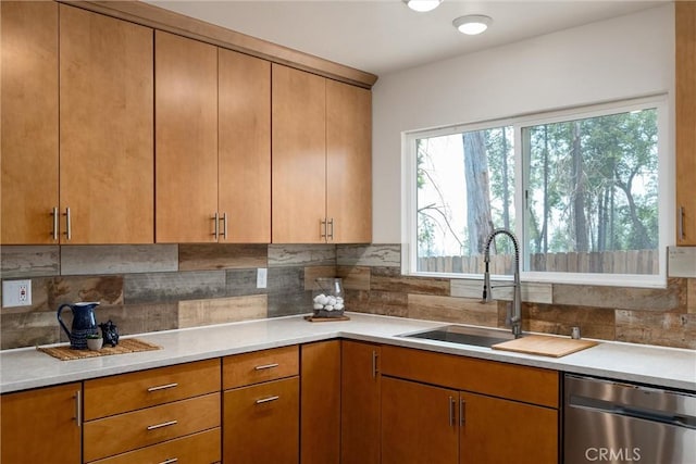 kitchen featuring backsplash, sink, and stainless steel dishwasher