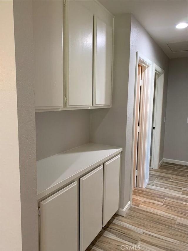 hall with recessed lighting, light wood-style flooring, and baseboards