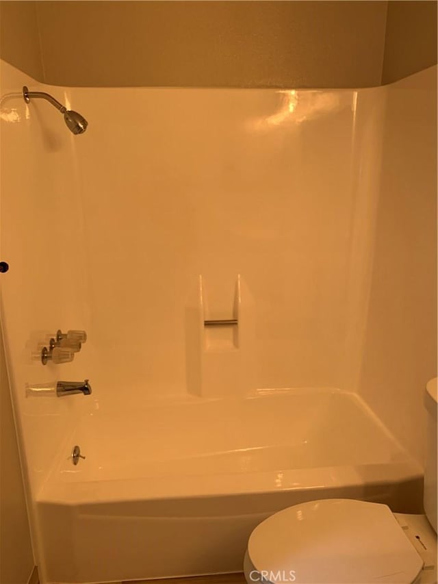bathroom featuring washtub / shower combination and toilet