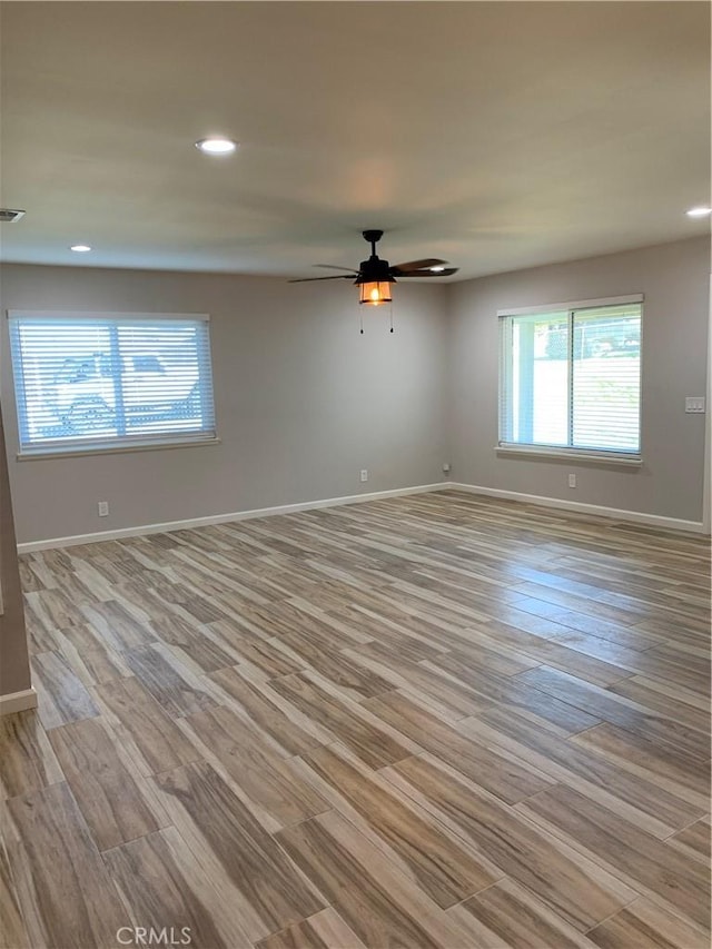 unfurnished room featuring a ceiling fan, visible vents, recessed lighting, wood finished floors, and baseboards