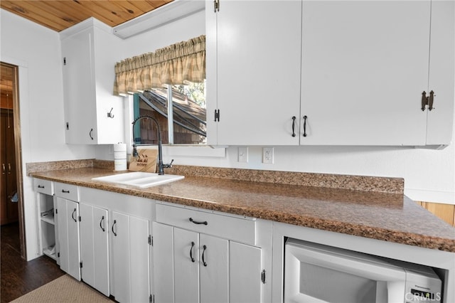 kitchen featuring dark hardwood / wood-style flooring, white cabinets, wooden ceiling, and sink