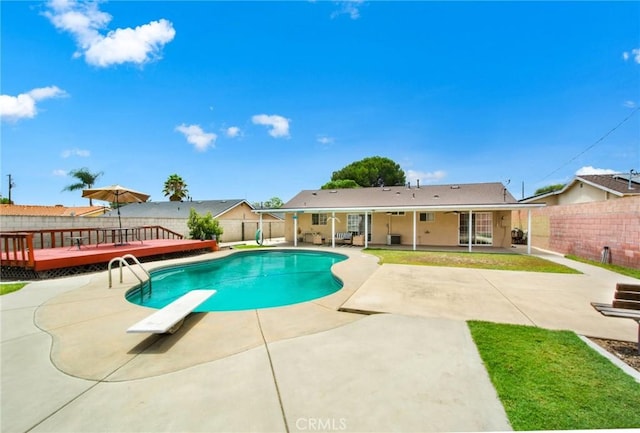 view of pool featuring a patio area, a diving board, and a wooden deck