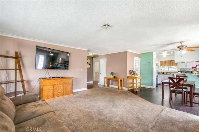 living room with ceiling fan, a textured ceiling, and ornamental molding