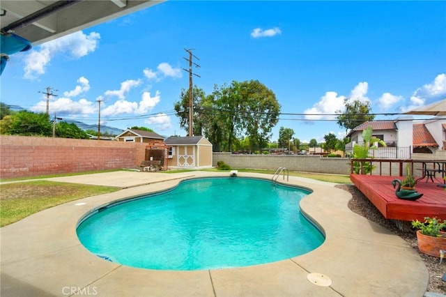 view of pool with a deck and a storage unit