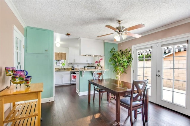 dining area with dark wood-type flooring, french doors, sink, ceiling fan, and ornamental molding