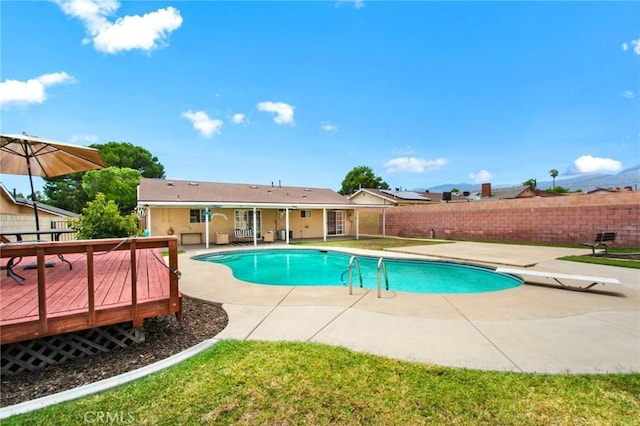 view of pool with a patio, a diving board, and a wooden deck