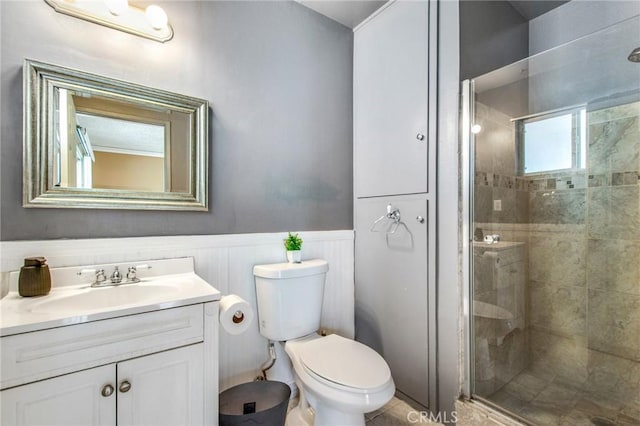 bathroom featuring vanity, a healthy amount of sunlight, toilet, and a shower with shower door