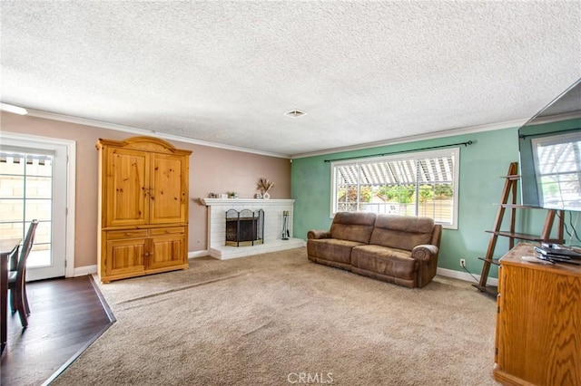 living room featuring carpet flooring, a fireplace, ornamental molding, and a textured ceiling