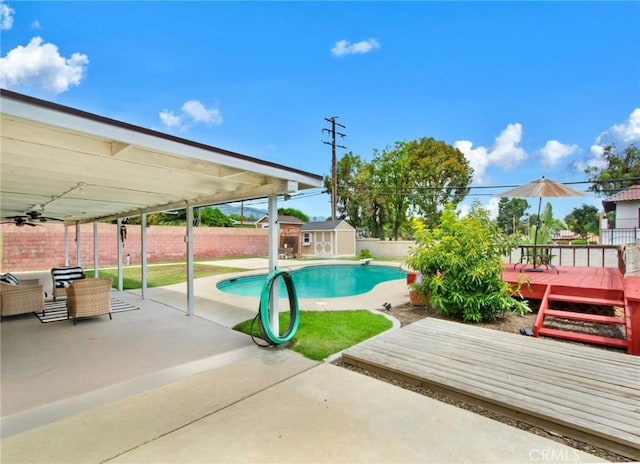 view of pool featuring a storage unit and a wooden deck