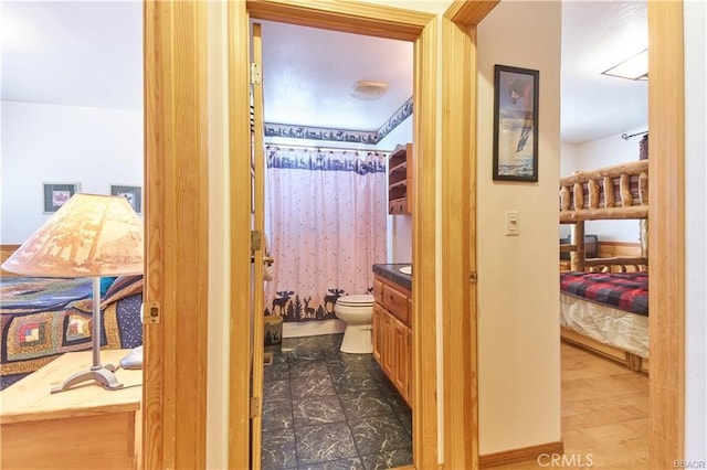 ensuite bathroom with toilet, vanity, a shower with shower curtain, and ensuite bathroom