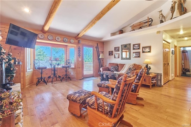 living area with vaulted ceiling with beams and wood finished floors