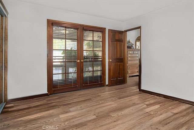 unfurnished room featuring hardwood / wood-style flooring and french doors