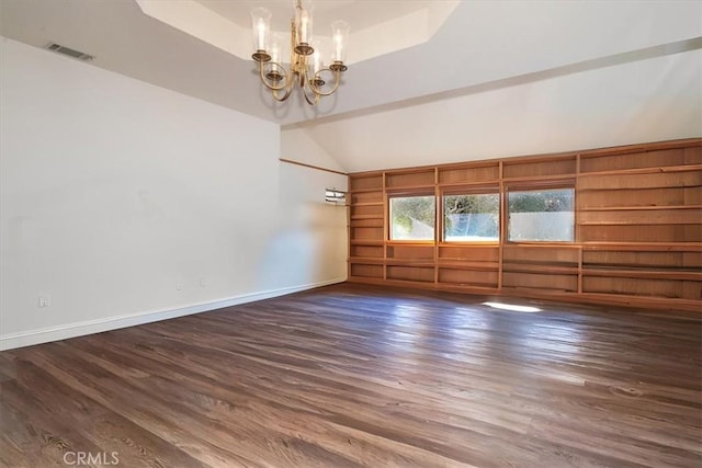 unfurnished room featuring dark hardwood / wood-style floors, a chandelier, and vaulted ceiling