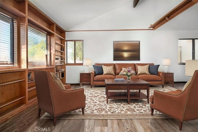 living room featuring hardwood / wood-style flooring, built in shelves, and vaulted ceiling