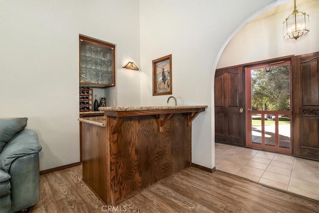 foyer entrance with hardwood / wood-style flooring and bar area