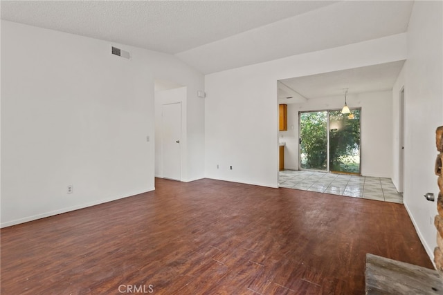 unfurnished living room featuring a textured ceiling, light hardwood / wood-style flooring, and lofted ceiling