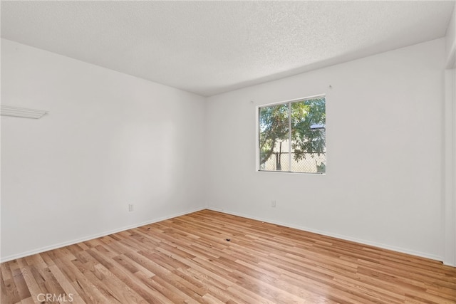 unfurnished room with a textured ceiling and light hardwood / wood-style floors