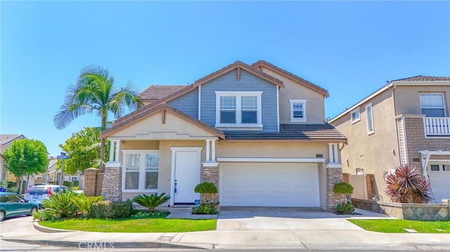 craftsman-style home featuring a tile roof, stucco siding, a garage, stone siding, and driveway