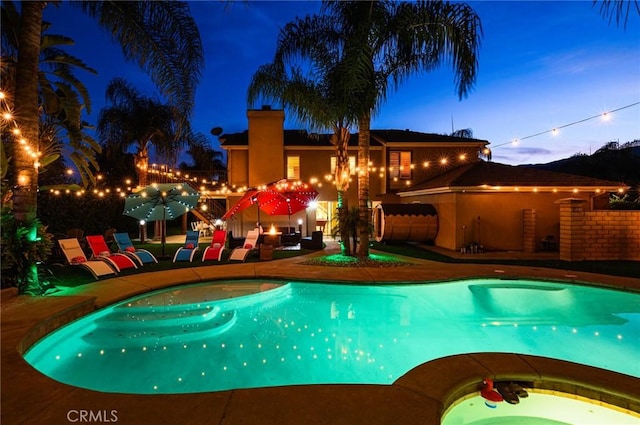 pool featuring a patio and an in ground hot tub