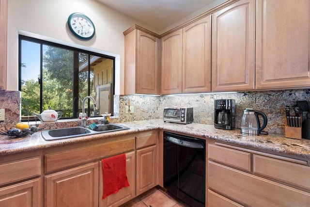 kitchen featuring black dishwasher, light stone counters, tasteful backsplash, sink, and light tile patterned floors