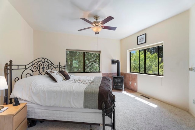 bedroom with multiple windows, ceiling fan, and carpet floors