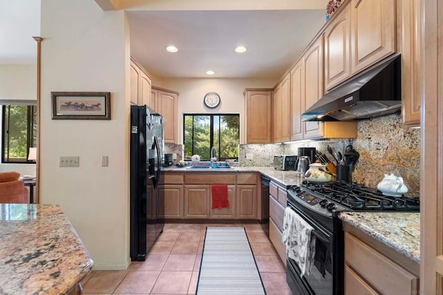 kitchen featuring light stone counters, light tile patterned floors, black appliances, light brown cabinetry, and sink