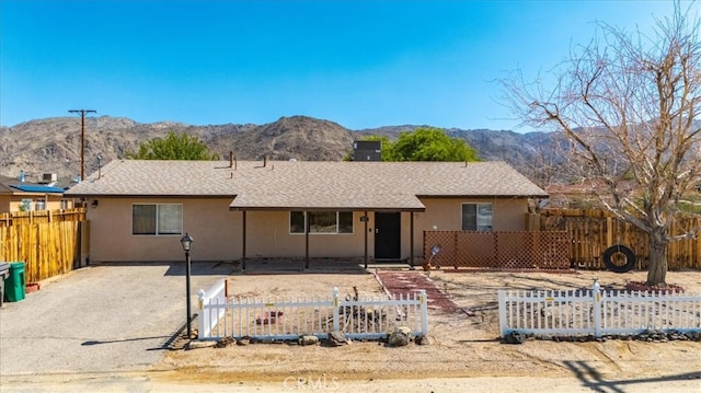 ranch-style house with a mountain view and a patio area