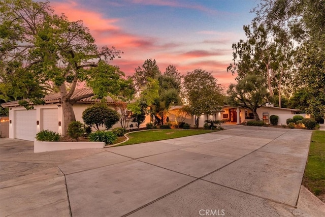 view of front of property featuring a garage and a lawn