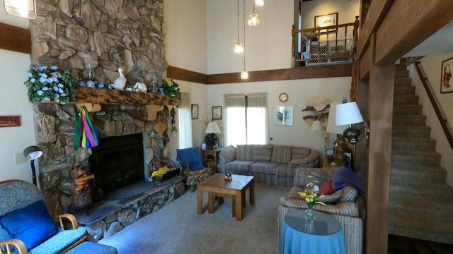 living room with a fireplace, a towering ceiling, and carpet flooring