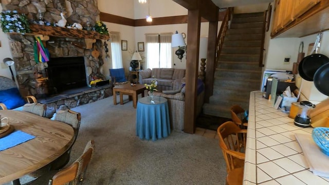 living room featuring a fireplace, a towering ceiling, and light colored carpet