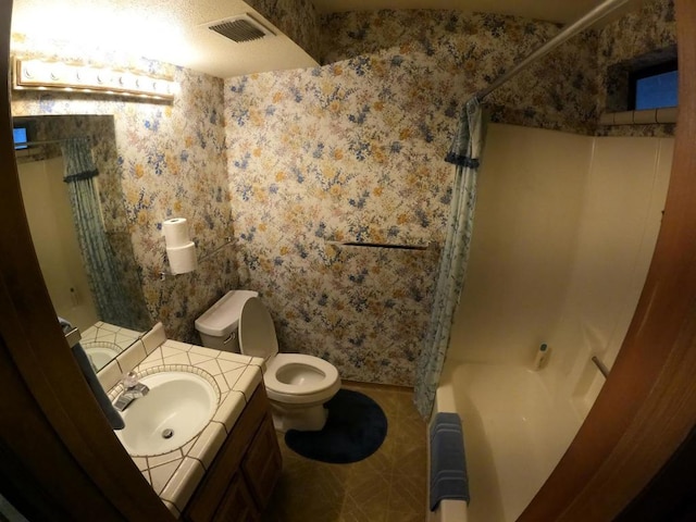 full bathroom with vanity, shower / tub combo, and toilet