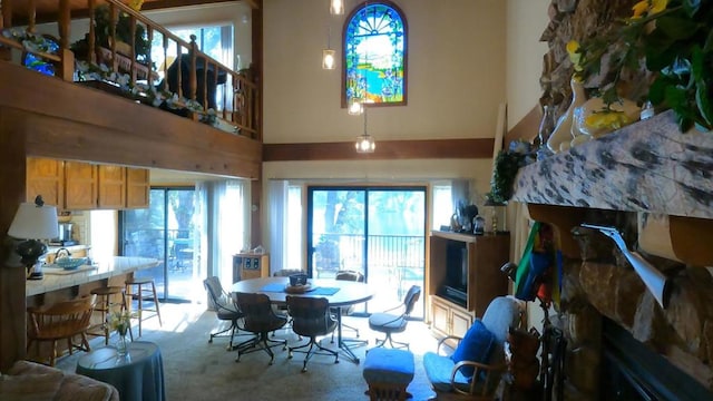 dining space with a high ceiling, light carpet, and plenty of natural light