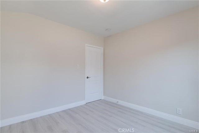 spare room featuring light wood-style flooring and baseboards