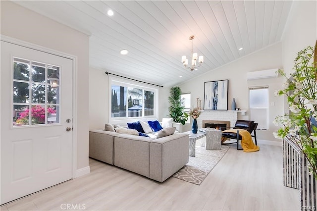 living room featuring wood ceiling, vaulted ceiling, a brick fireplace, light wood-type flooring, and a wall unit AC