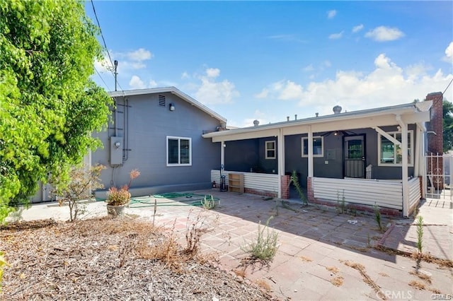 back of house featuring a sunroom and a patio