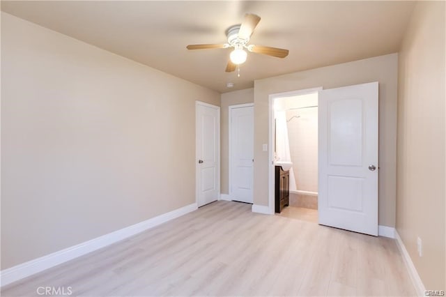 unfurnished bedroom with connected bathroom, ceiling fan, light wood finished floors, and baseboards