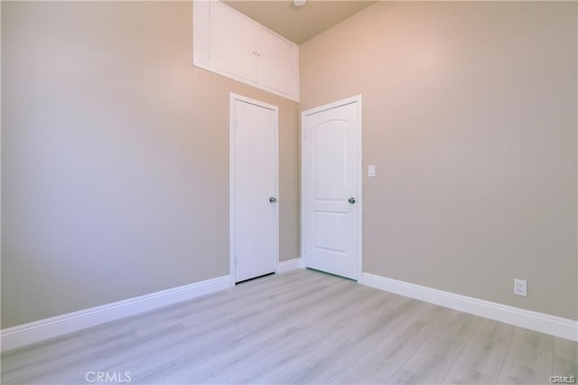 spare room with light wood-style floors and baseboards