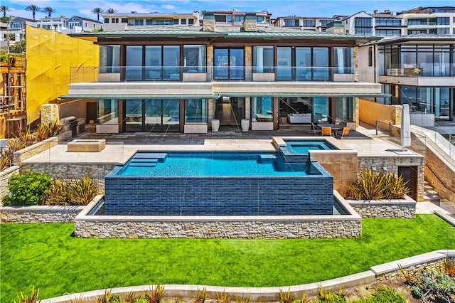 rear view of house featuring a pool with connected hot tub, a patio, a balcony, and metal roof