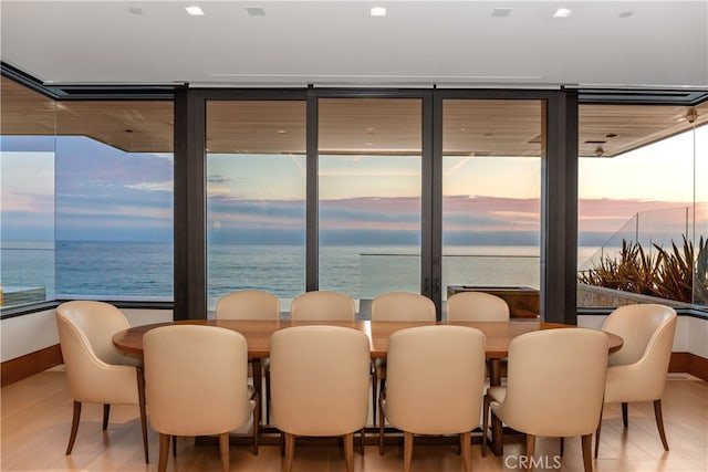 dining space with a water view and wood finished floors