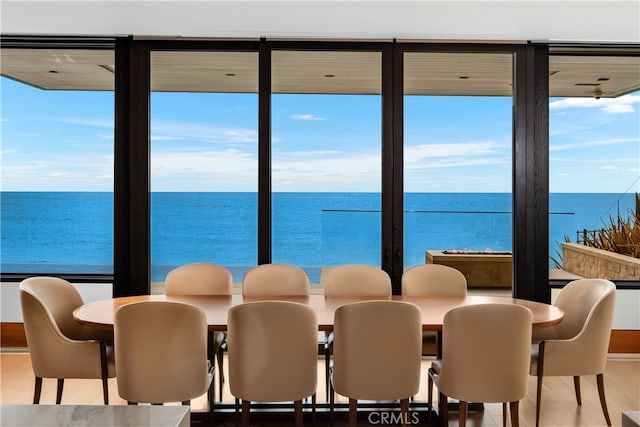 dining area with a water view and wood finished floors