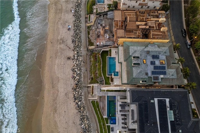 birds eye view of property with a water view and a view of the beach