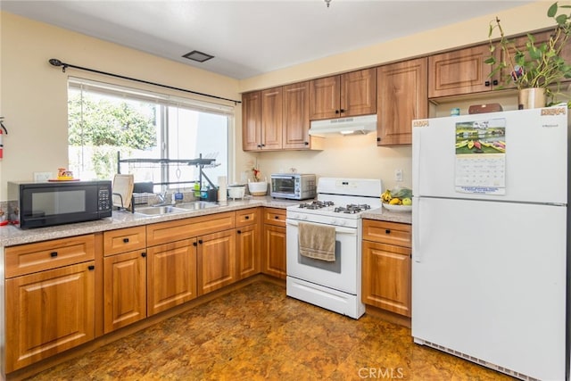 kitchen featuring light stone countertops, white appliances, and sink