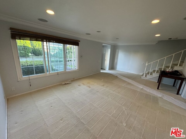 unfurnished living room featuring light colored carpet and crown molding