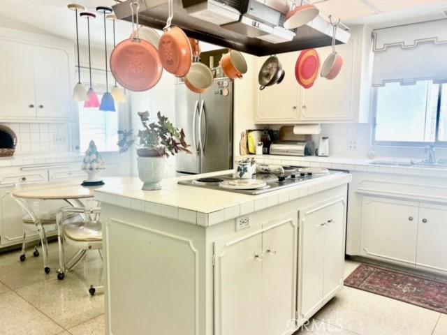 730 Santiago Ave, Long Beach, CA 90804 - kitchen featuring freestanding refrigerator, tile counters, tasteful backsplash, and a sink